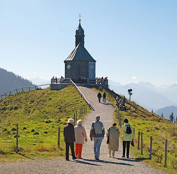 Menschen pilgern zu einer Kapelle auf den Berg