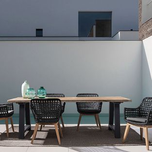 Holztisch wetterfest mit schwarzen Rattanstühle auf Terrasse