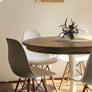 Runder Holztisch mit weißen Stühlen